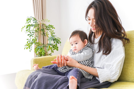 Mother and daughter playing together at home. Asian family lifestyle concept.