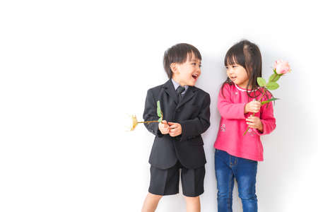 Asian children with a bouquet of flowers on a white background.の写真素材