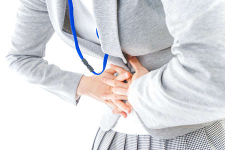 Woman suffering from stomachache and holding stethoscopeの写真素材
