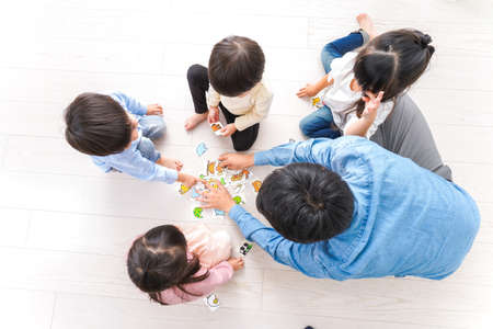 Top view of a group of asian children playing jigsaw puzzle game togetherの写真素材