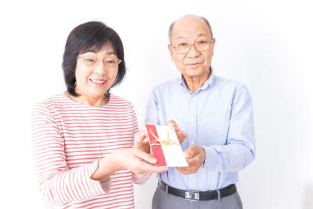 Asian senior couple with gift box on white background,Elderly peopleの写真素材
