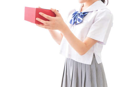 Student holding a red book in high school high school student uniform.の写真素材