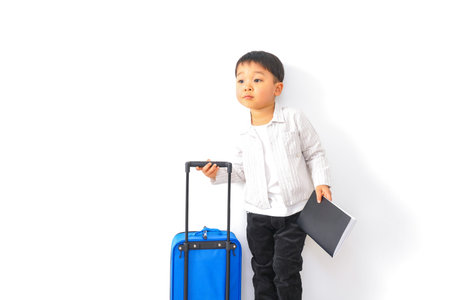 A boy with a suitcase and a laptop on a white background.
