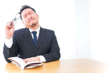 Tired businessman reading booksの写真素材