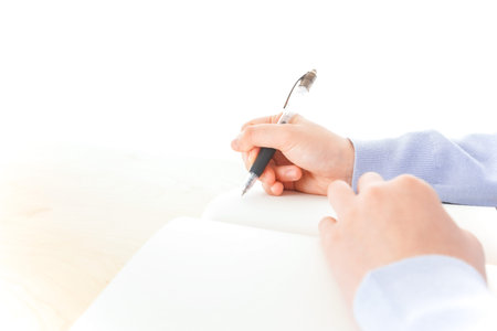 Hands of a doctor writing on a white sheet of paper.