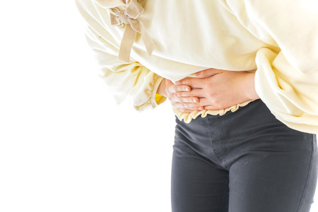 Woman suffering from stomachache on white background, closeup. Health care concept