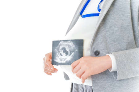 A pregnant woman holding an ultrasound image of her baby, isolated on white backgroundの写真素材