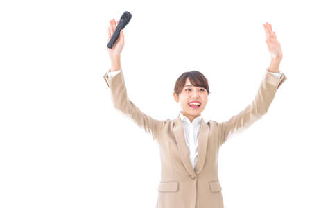 Young business woman with a microphone shot in the studio on white backgroundの写真素材