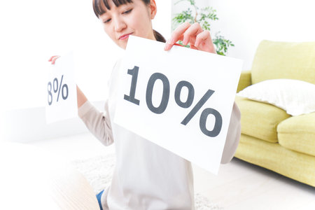 Woman showing a 10 percent off sign in the living room at home