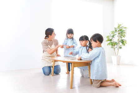 Japanese family playing board game in the living room (3 years old)の写真素材
