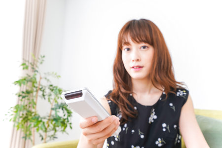 Woman watching TV at homeの写真素材