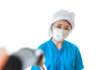 Portrait of young Asian female surgeon wearing surgical mask and holding drill