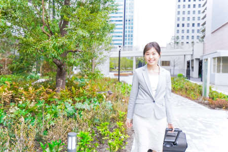 Businesswoman walking on the street and carrying a briefcase photoの写真素材