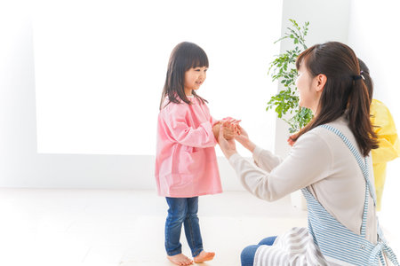 Mother and daughter playing together at home in the living room, happy family concept.