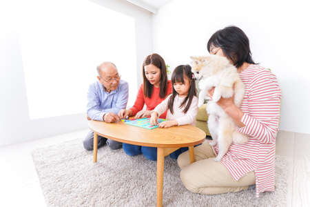 Asian family playing with dog in the living room at home high quality photoの写真素材