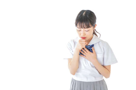 Schoolgirl having a sore throat shot in the studio on white backgroundの写真素材