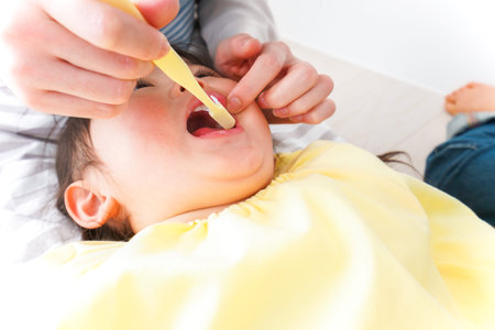 Mother feeding her baby with a spoon. Close-up shot.