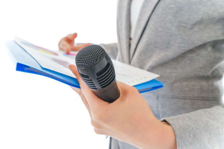 Close-up of female hands holding microphone and documents isolated on white backgroundの写真素材