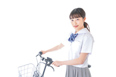 A young woman riding a bicycle shot in the studio on a white background