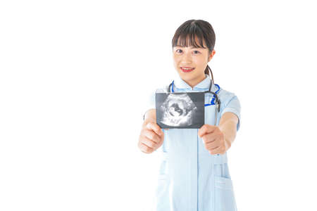 A female doctor holding an x-ray image taken in the studioの写真素材
