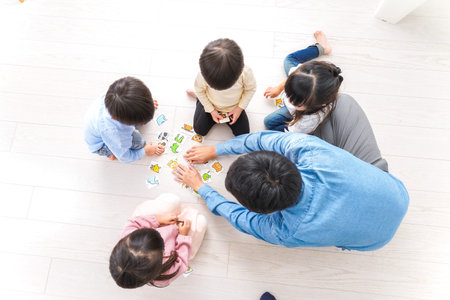 Top view of a group of children playing board game together at home