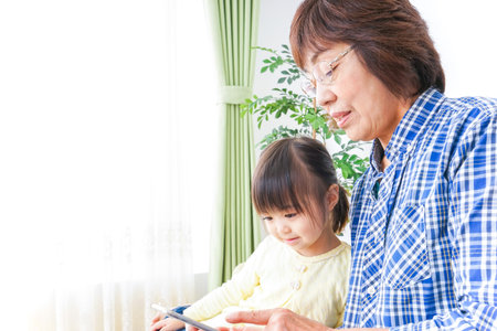 Child using smartphone with grandmother