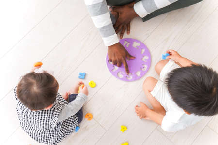 Top view of mother playing with her son and daughter at homeの写真素材