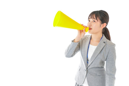 A young business woman shouting through a megaphone shot in the studio