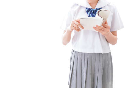 School uniform of the first grade high school high school girl holding a bookの写真素材