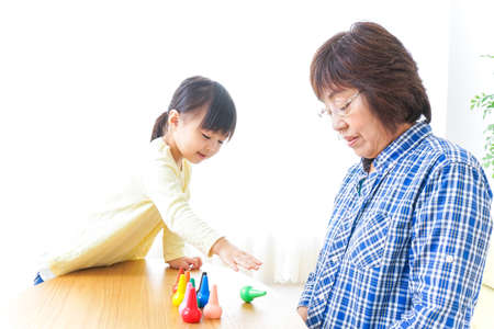 Child playing a game with grandmotherの写真素材