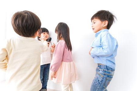 Children and teacher in front of a white wall shot in the studio
