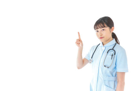 Nurse pointing at copy space, closeup portrait on white background.の写真素材