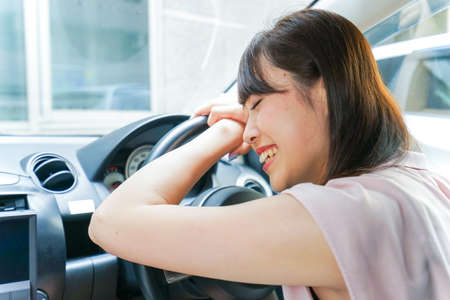 Young woman sleeping in carの写真素材