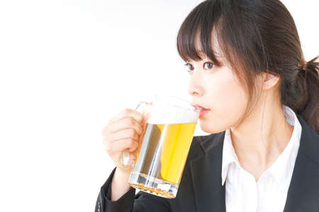 Businesswoman in suit cracking a beerの写真素材