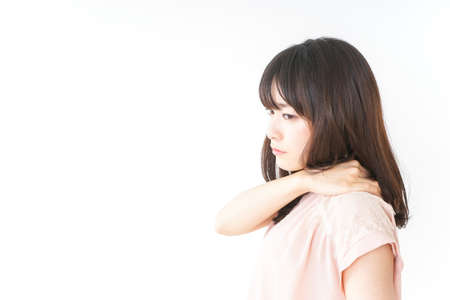 Young woman feeling stiff in her shouldersの写真素材