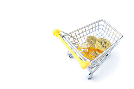 Shopping cart with gold coins isolated on white background. Copy space.の写真素材