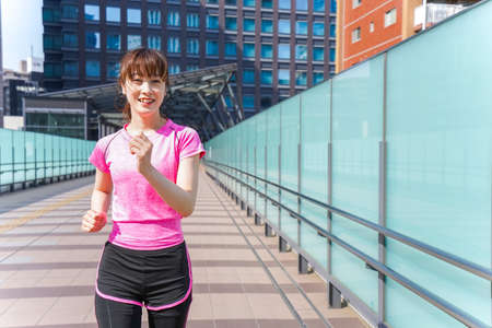 Woman running in cityの写真素材