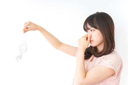 Young woman smelling stinky laundriesの写真素材