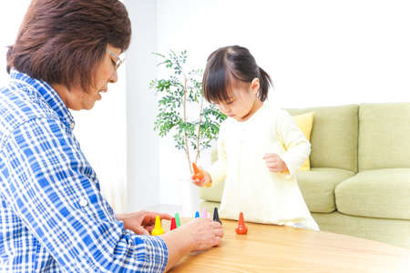 Child playing a game with grandmotherの写真素材