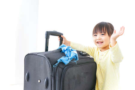 Child carrying a suitcaseの写真素材
