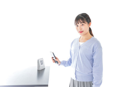 Young woman paying with smartphoneの写真素材