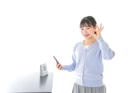 Young woman paying with digital moneyの写真素材