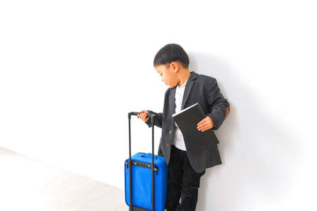 Young man with a suitcase on a white background.の写真素材