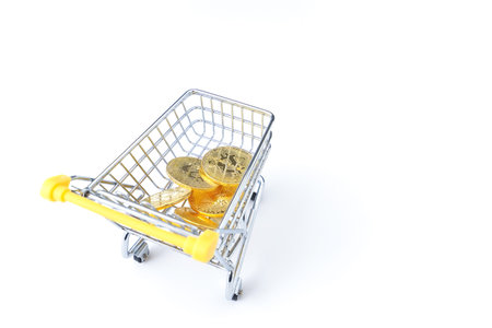 Shopping cart with golden coins isolated on white background. Online shopping concept.