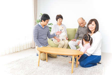 Three-generation family taking care of dogの写真素材