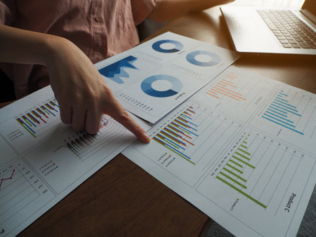 Businesswoman pointing at a graph online meeting planning to work working from homeの写真素材