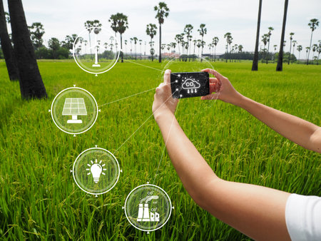 hand of a girl holding a smartphone show connection Concept connecting modern business and technology in access and CO2 emissions. Green business concept using renewable energy. There is light insideの写真素材