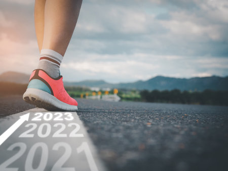 Step into 2023, female athlete walking on white line on road with text Going through each year and preparing to enter the new yearの写真素材