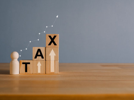 Tax concept with rising wooden blocks Expenses that are running higher than incomeの写真素材