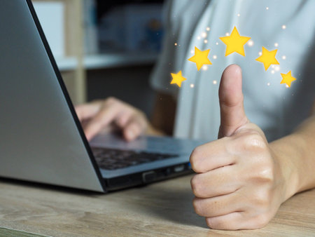 Businesswoman showing five star rating and thumbs up using laptop. Satisfaction concept.の写真素材
